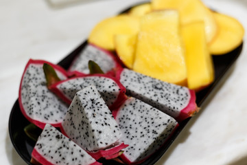 Large ripe pieces of juicy fresh mango and pitahaya. Useful and exotic fruits. The concept of a...