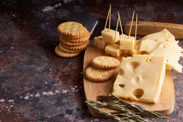 Pieces of cheese, nuts, raisins, snacks for wine on a wooden background. Appetitive