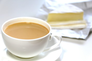 Coffee with milk. White cup. Soft brie cheese. Morning. Tasty breakfast.