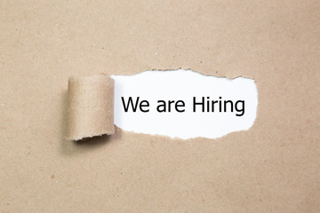 We're Hiring written under torn paper