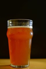 Glass of craft beer with foam black background