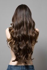 Naklejka premium Rear View Of Topless Woman With Long Wavy Hair