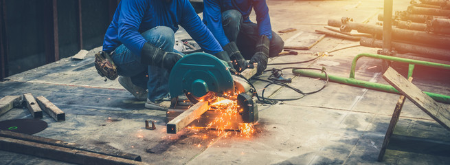 Close up view of professional focused two worker man in uniform working on the metal pipe