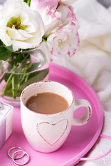 A tray with a cup of coffee, gift box, flowers and rings on the bed. Valentine's Day Wedding Offer