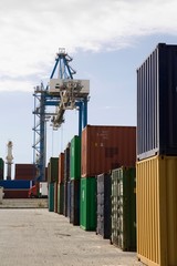 Stacked Containers And Crane In Stockyard