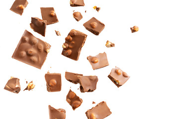 Flying in the air broken bar of milk chocolate with nuts and flakes isolated on white background. ...