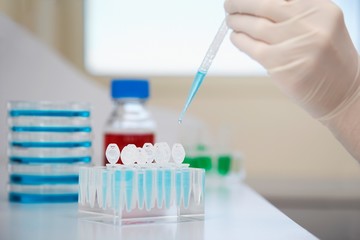 Gloved Hand Filling Test Tubes With Pipette