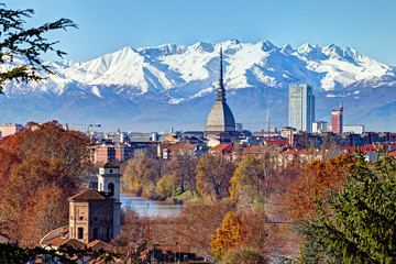 Aerial panoramic winter view on Turin city center with Mole Antonelliana, modern skyscrapers and other buildings, clear blue sky morning with Alps full of snow on background