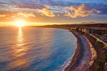 Photo sur Aluminium Nice Vue impressionnante sur le coucher de soleil sur le front de mer de Nice depuis la colline du château, avec un ciel et des nuages tumultueux et une lumière chaude