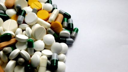 pills close up of different shapes and colors are scattered 