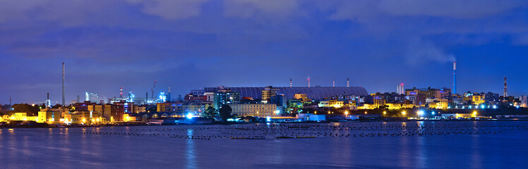 Night view on the building for the covering of mineral deposits in the Arcelormittal company (formerly Ilva) in the industrial area of Taranto, on the outskirts of the city and Tamburi district