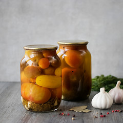 Pickled tomatoes in a glass jar.