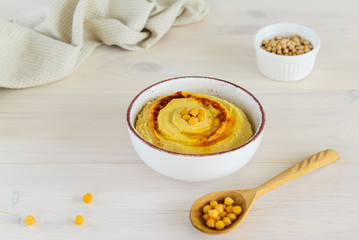 Hummus in a bowl on a wooden table.