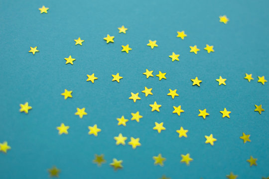 Modern festive flat lay background with gold stars glitter on blue paper backdrop. Minimalist design. © Tatiana Parfenteva