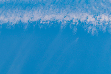 Fototapeta na wymiar A band of white clouds on a blue sky background