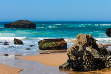 Fototapeta na wymiar Rocky beach at sunrise, Atlantic ocean coast, Adraga, Portugal. Travel and business background