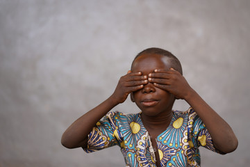Handsome and cute African Boy closing and covering his eyes