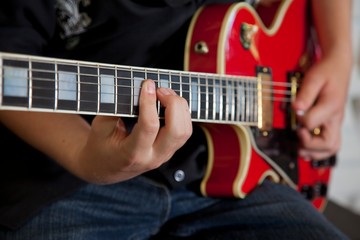 Fototapeta na wymiar Close-up of young woman's hand playing guitar