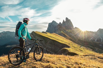 Jonge man met mountainbike op Seceda bergtop bij zonsopgang. Puez Odle, Trentino, Dolomieten, Italië.