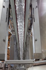 Obraz premium Bottling plant with clear bottles hanging