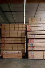 Stack of wooden plywood with markings in warehouse