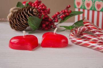 Two red  heart shaped candles, gift and Christmas ornaments. Christmas still life concept.
