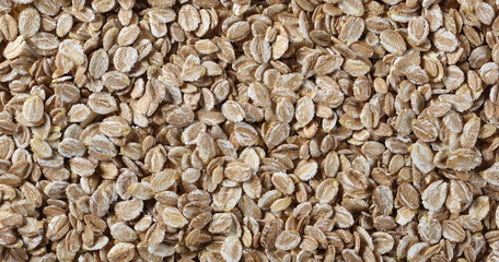 Flakes, rye grain cereal for breakfast background and texture