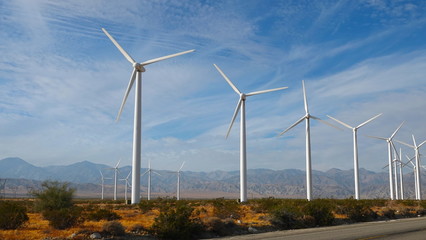 Wind turbines under pretty blue sky with clouds 