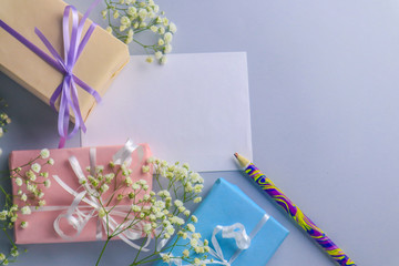 Cute gift boxes and flowers on color background