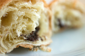 Broken in half croissant with chocolate closeup