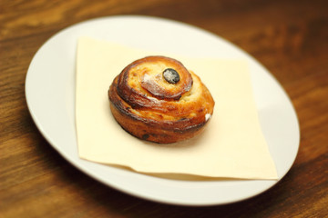Bread Roll with raisins and cottage cheese filling on a wooden plank table