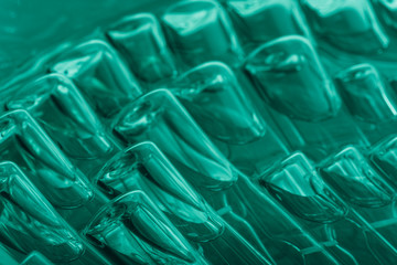 Glass medical ampoule vial for injection. Medicine is liquid sodium chloride with of aqueous solution in ampulla. Close up. Bottles ampule multicolor on background color and water. Human plasma.