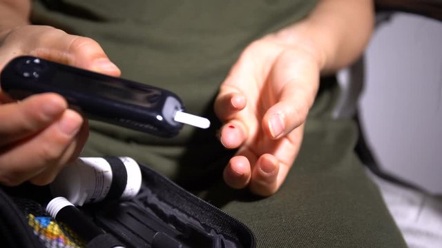Self-Testing For Diabetes. Woman Using Glucomete And Waiting For The Result