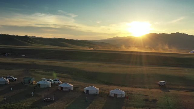 Aerial view of traditional yurts between montains at sunset, Mongolia, 4k