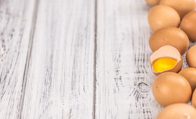 Wooden table with Raw Eggs (detailed close-up shot; selective focus)