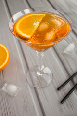 Aperol spritz cocktail in martini glass on the grey wooden background.  Location vertical. Copy space.