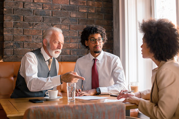 Two representatives of a small enterprise are about to sign a contract with their business partner.