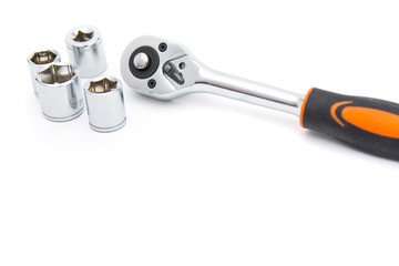 Ratchet wrench with black and orange handles with set of heads for it, isolated over a white...