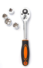 Ratchet wrench with black and orange handles with set of heads for it, isolated over a white background. Tools and hardware for everyday. Construction and repair.