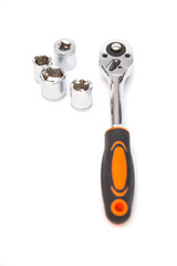 Ratchet wrench with black and orange handles with set of heads for it, isolated over a white background. Tools and hardware for everyday. Construction and repair.