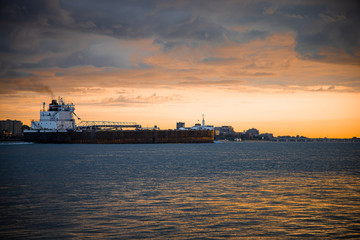 cargo ship heading down the Detroit river and into the sunset