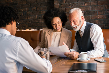Two co-workers reviewing the latest projections about their business provided by the younger employee.