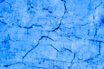 Abstract background of blue color imitation of cracks on plaster.