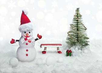 Cheerful snowman next to the tree and bench. Creative collage.