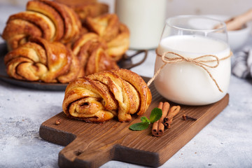 Buns from yeast dough with brown sugar and cinnamon. Delicious homemade dessert served with a glass of milk. 