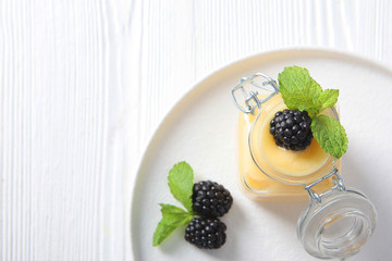 Honey in a glass jar and blackberries . Photo on white background. Copy space.