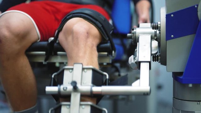 Recovery equipment at a modern clinic. Athletic young man patient going through training therapy rehabilitation