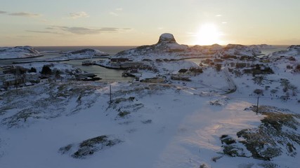 Winter sunset over Husøya village and port, Træna islands, Nordland, Northern Norway, aerial drone shot
