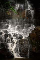 Fototapeta na wymiar Amazing waterfall in dark rocks