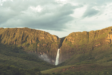 Amazing waterfall in the canyons of Minas Gerais during the sunset with clouds in the sky in Brazil